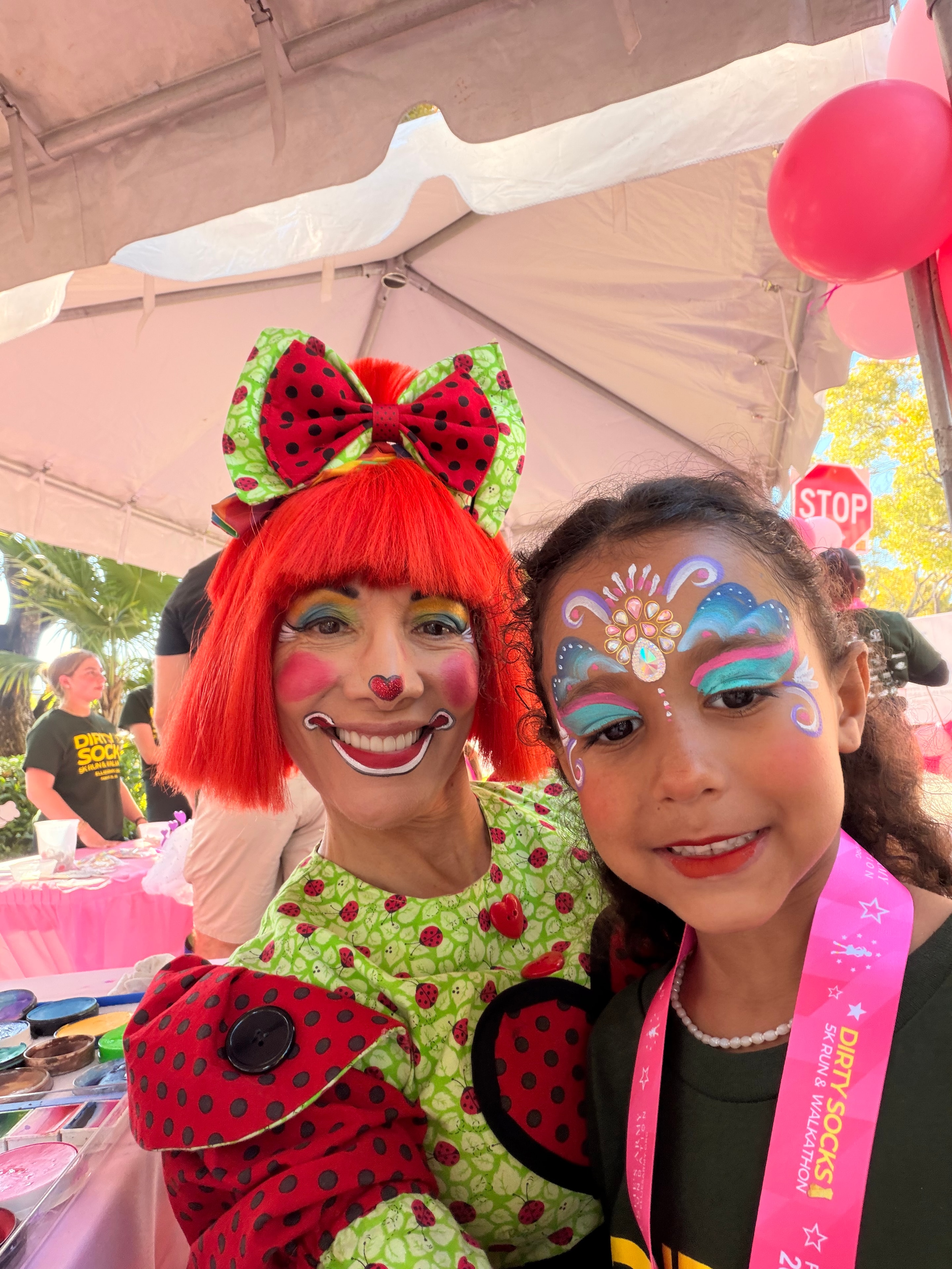 Flower face painting with OOOPSY clown performer at outdoor event
