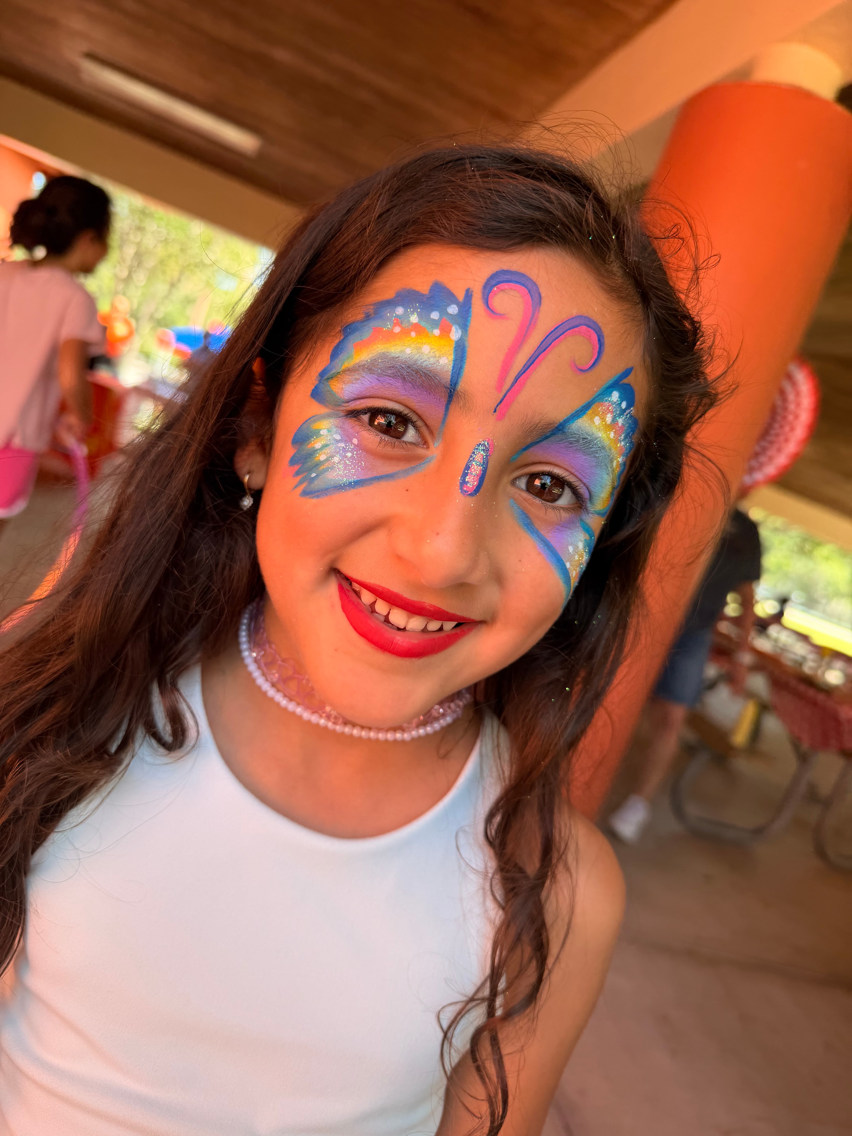 Rainbow butterfly face painting by OOOPSY Face Painting Team