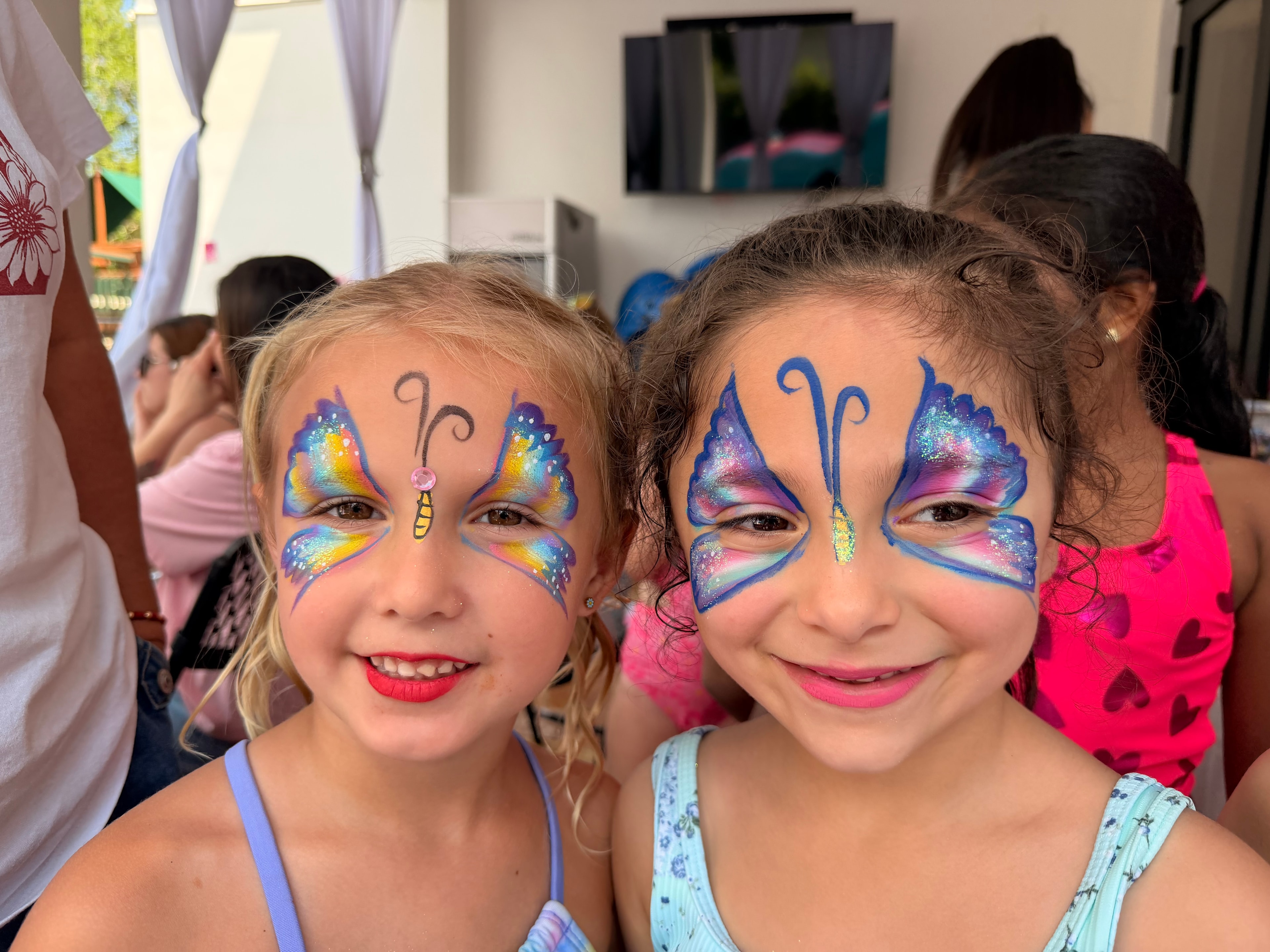 Two girls with matching butterfly face paint by OOOPSY Face Painting Team
