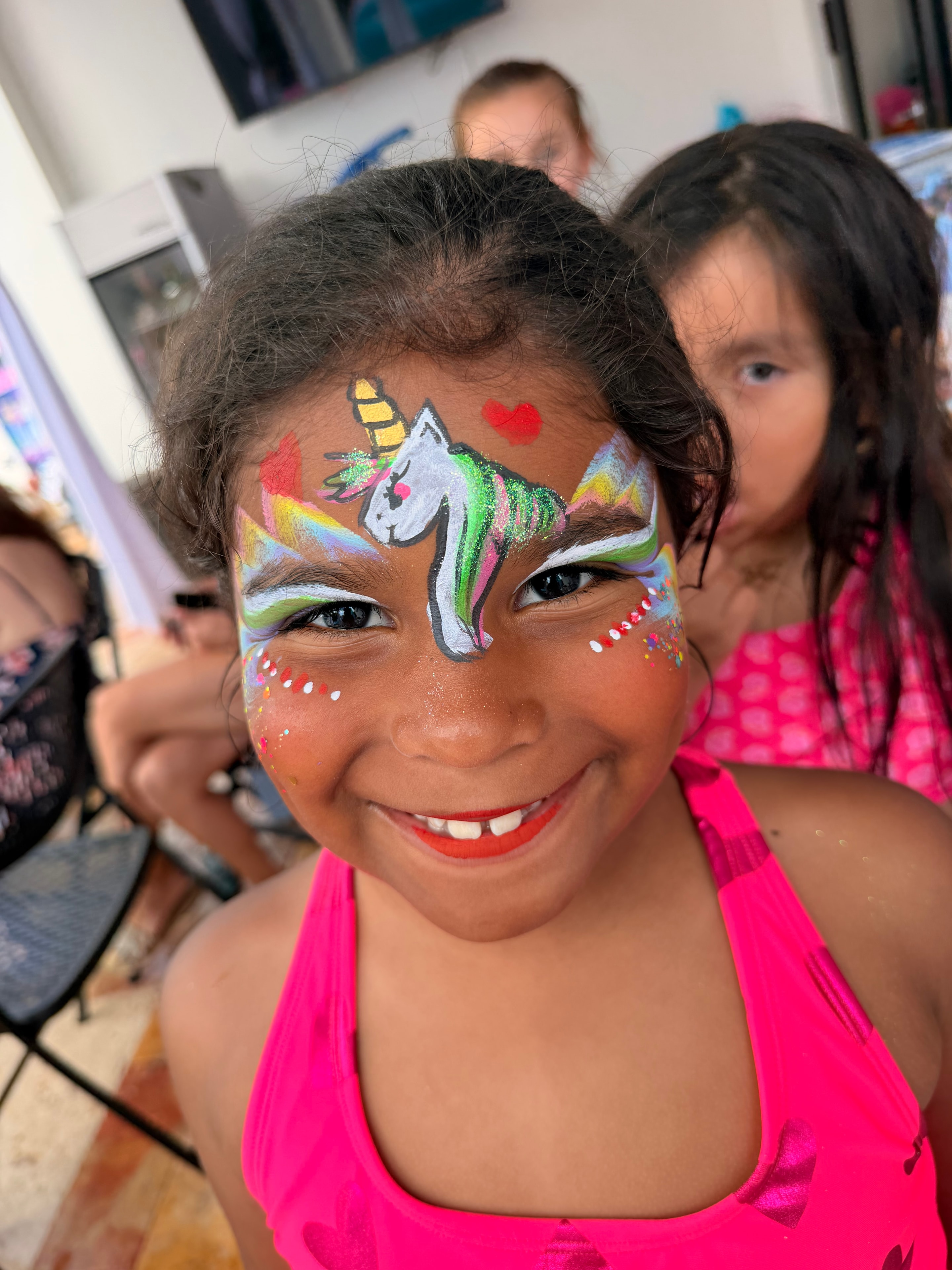 Colorful unicorn face painting by OOOPSY Face Painting Team